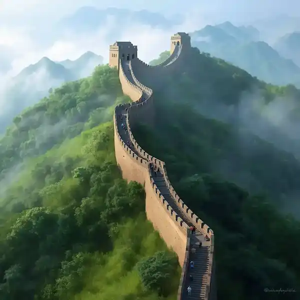 The great wall of China on a misty morning with snow capped mountains in the background