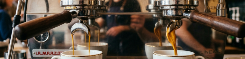 espresso machine group heads extracting espresso into coffee cups